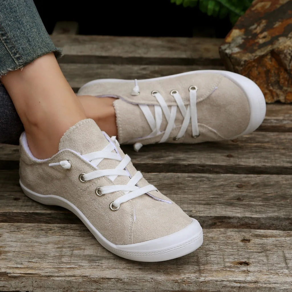 Women's creamy white casual low-top sneakers with fabric upper and rubber sole on a neutral background.