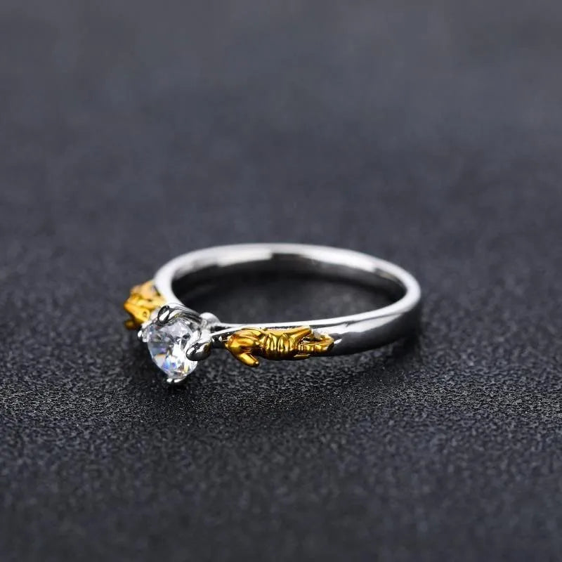 Black gold finished copper ring with a detailed crown motif and crystal settings on a finger.