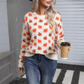 Beige and dark green loose fit Christmas sweater with maple leaf design and round neck.