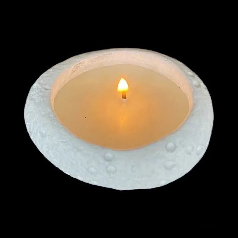 White cement candlestick ornament with fair-faced finish holding a candle