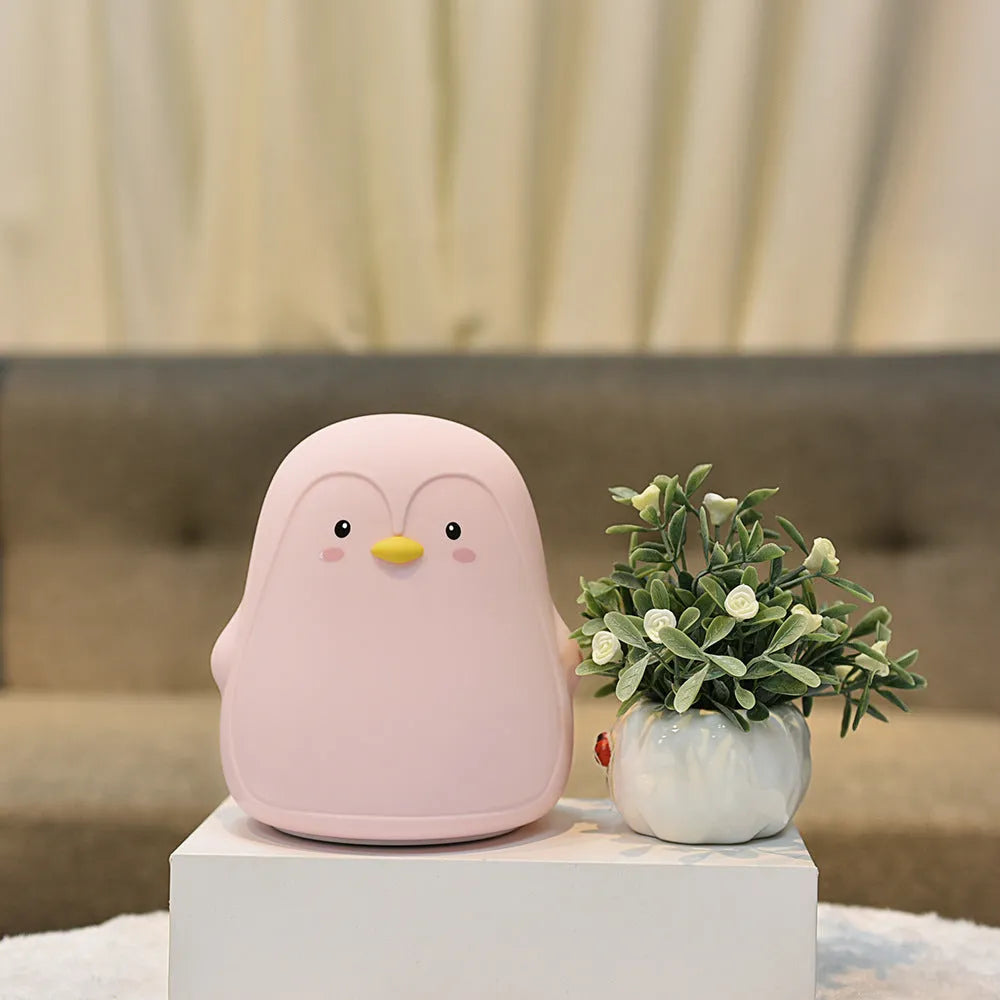 Penguin-shaped silicone and ABS night light with white LED glow, shown with USB charging cable.