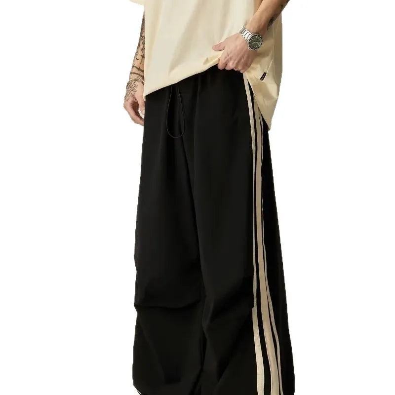 Black men's wide-leg high-waist climbing trousers laid flat, showing straight-leg cut.