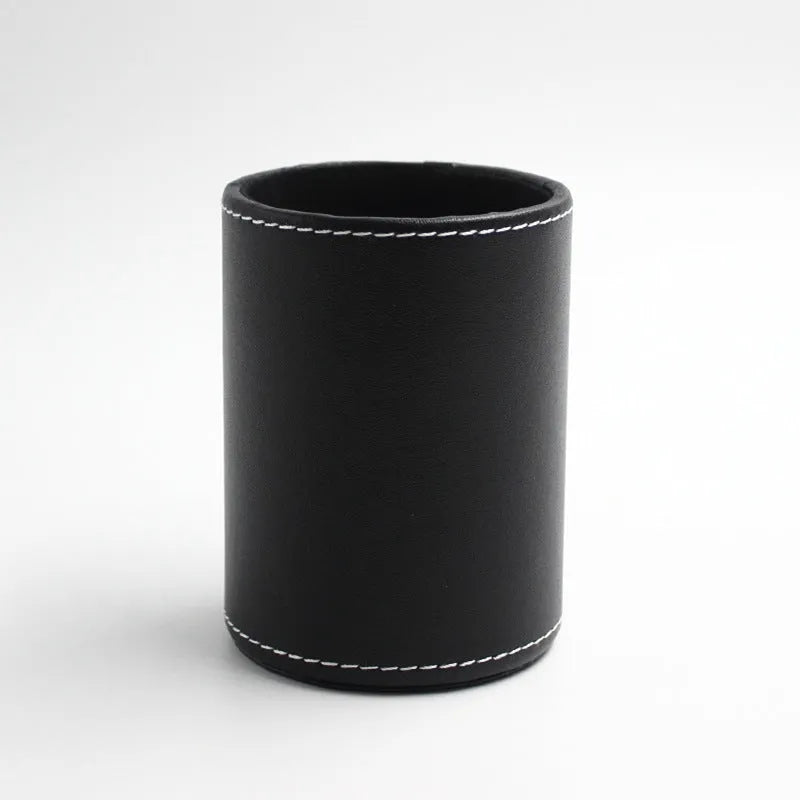 Black leather round pen holder on a desk
