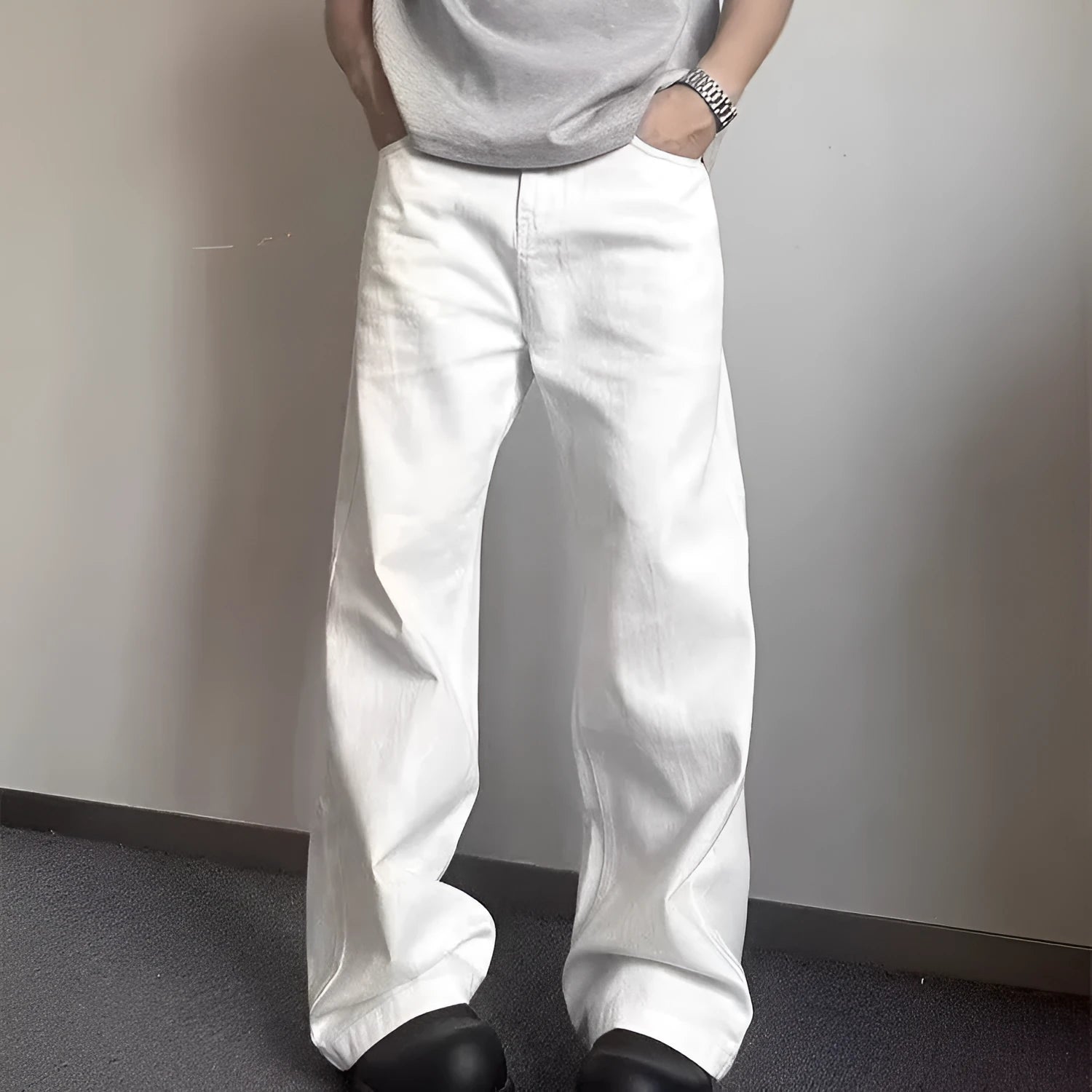 Men's white straight-leg denim jeans with a wide fit and mid-rise waist on a plain background.