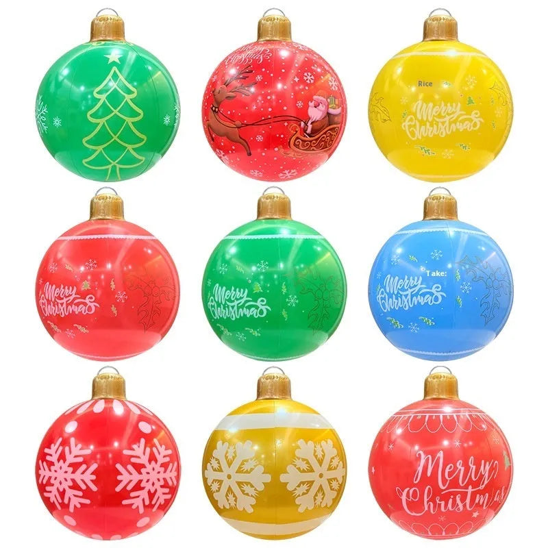 Large red inflatable Christmas ball with snowflake design and flashing lights in a garden setting.