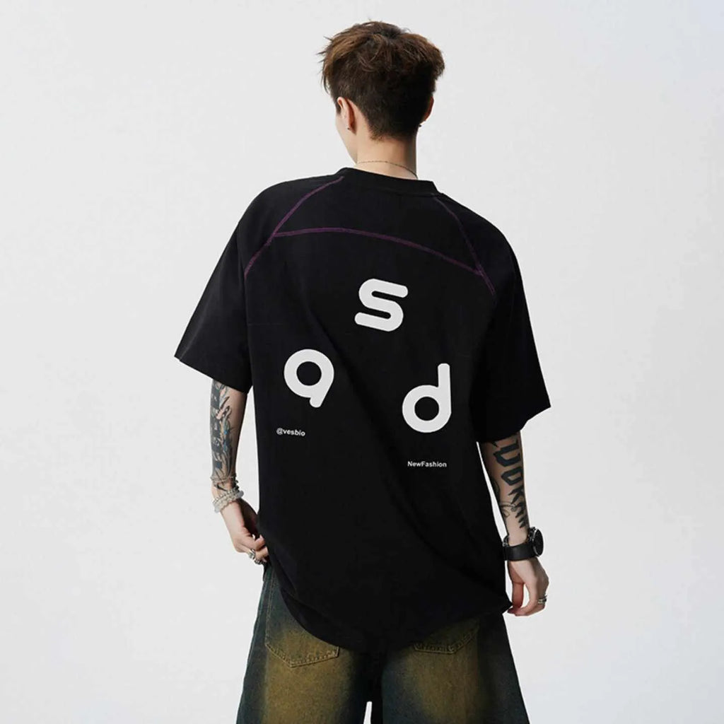 Man wearing a loose-fitting black cotton T-shirt with a white letter print on the chest.