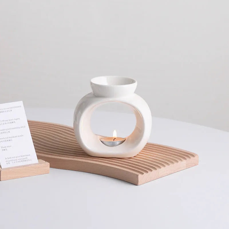 White Nordic style ceramic aromatherapy stove ornament on a wooden surface.