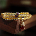 Natural Brazilian rutilated quartz bracelet in Chinese style with three circles and hanging chopsticks.