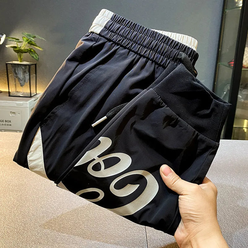 Men's black ultra-thin ice silk ankle banded cropped trousers on hanger