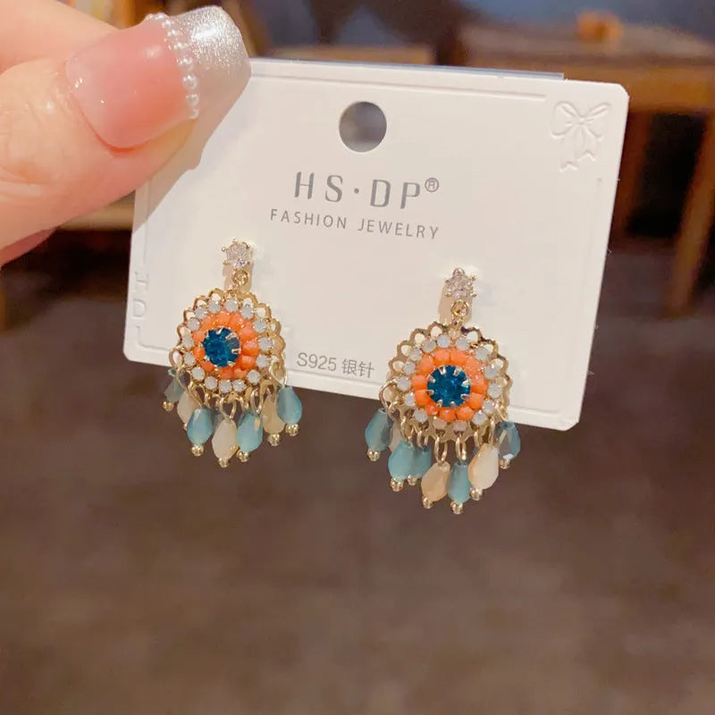 Women's round crystal tassel earrings with embedded diamonds in blue and purple geometric designs