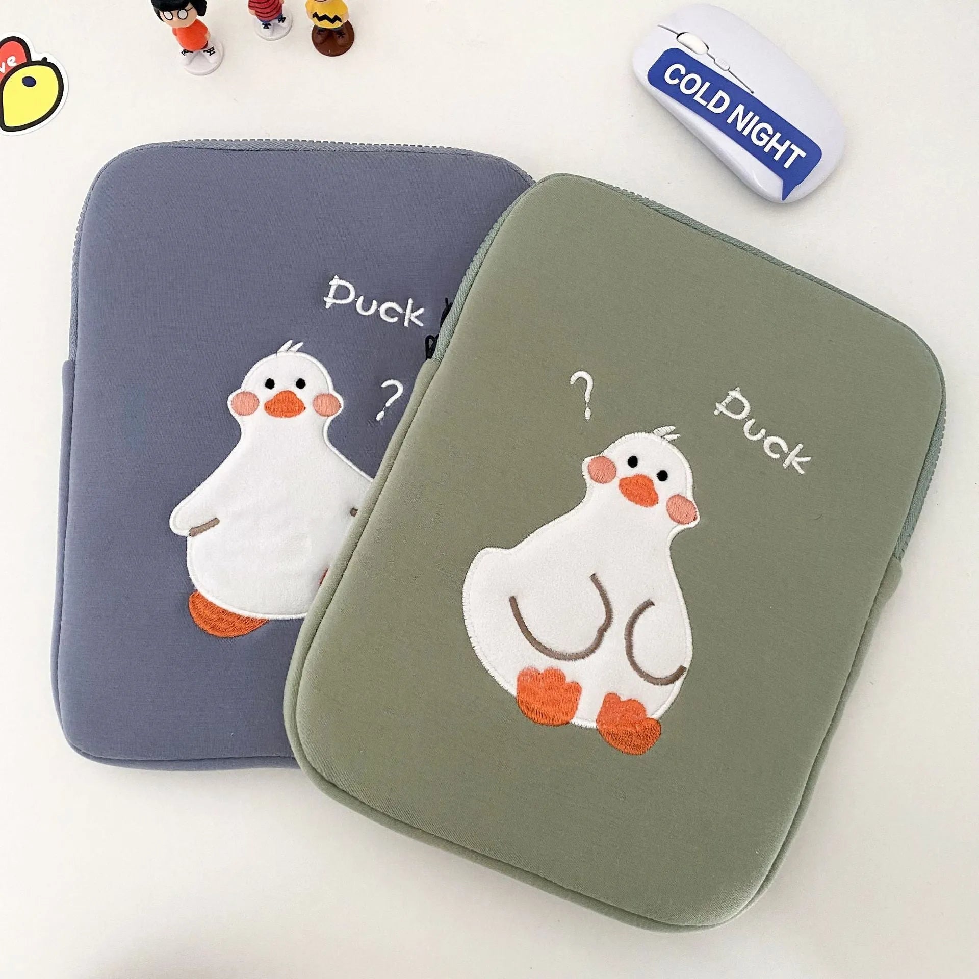 Blue cotton tablet case with an embroidered cartoon duck design and a silver zip closure.