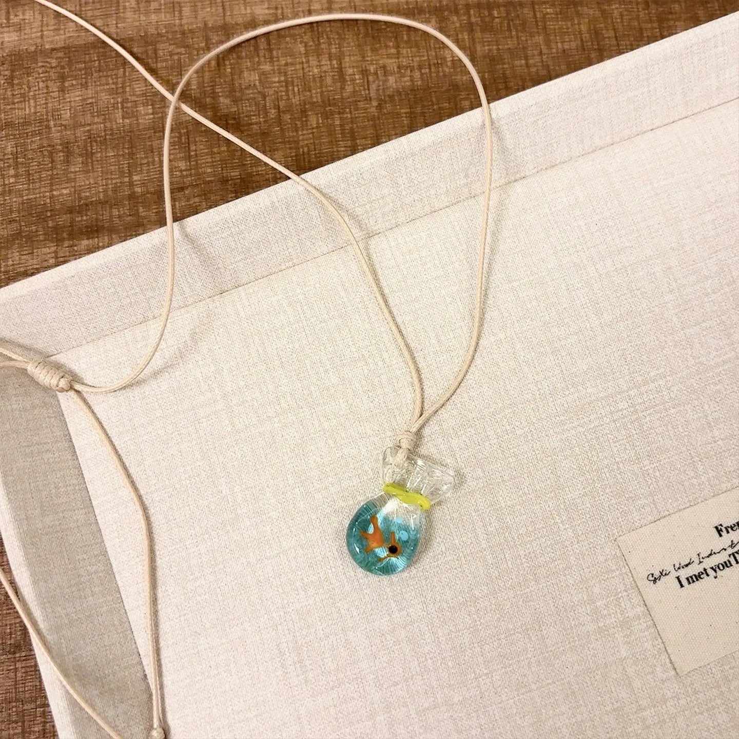 Women's necklace with a colourful skirt joker pendant on a long, braided cotton and linen chain.