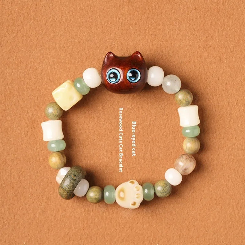 Hand-woven beaded bracelet with bodhi, jade, and ebony beads featuring a cartoon cat's paw charm.