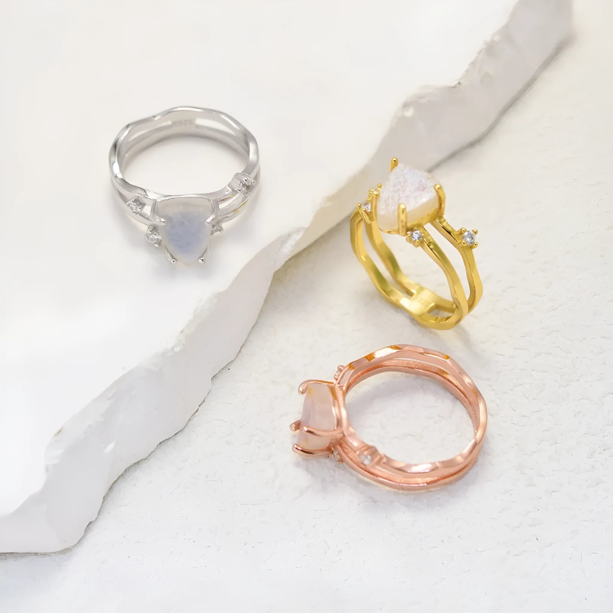 S925 silver geometric ring with irregular triangle shape and moonstone on a model's hand.