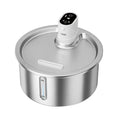 White stainless steel pet water fountain with digital thermostat base on a wooden table.