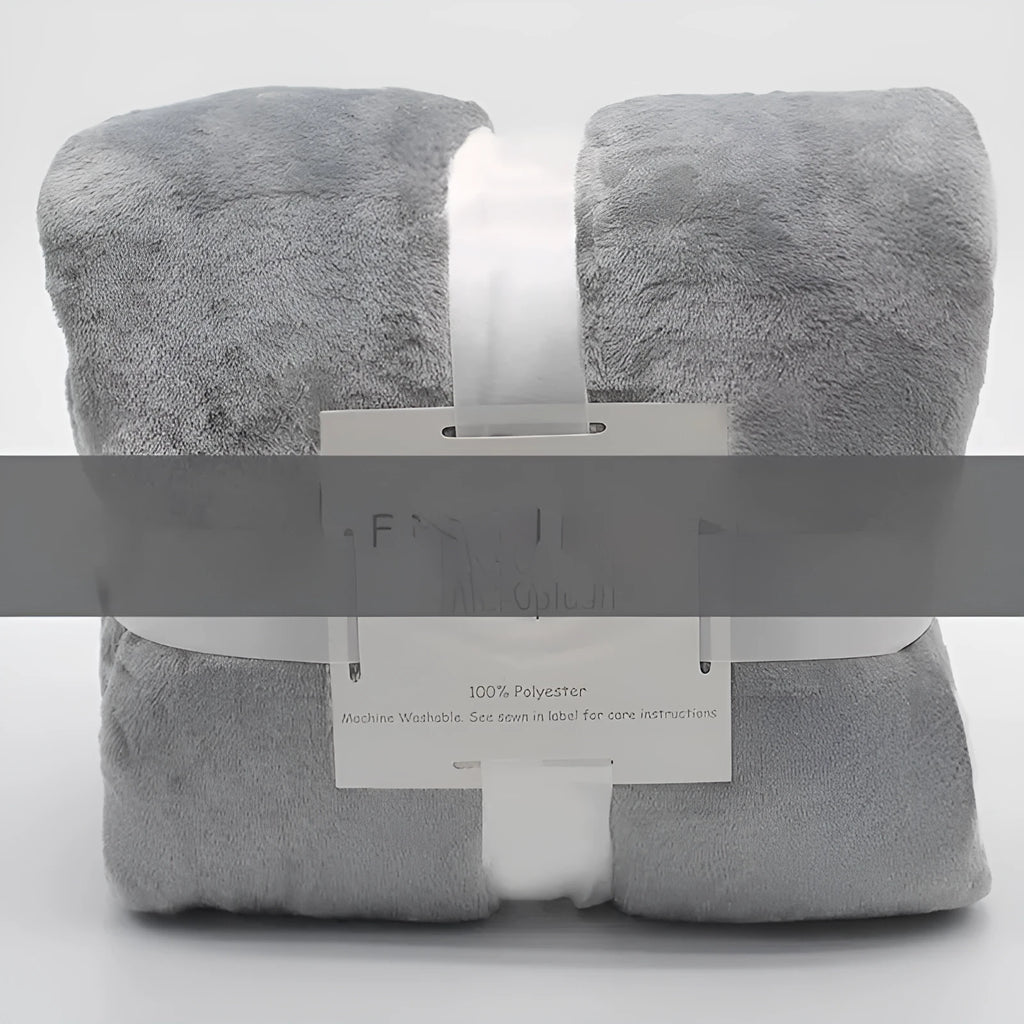 Light gray coral flannel polyester air conditioning blanket folded on a neutral background