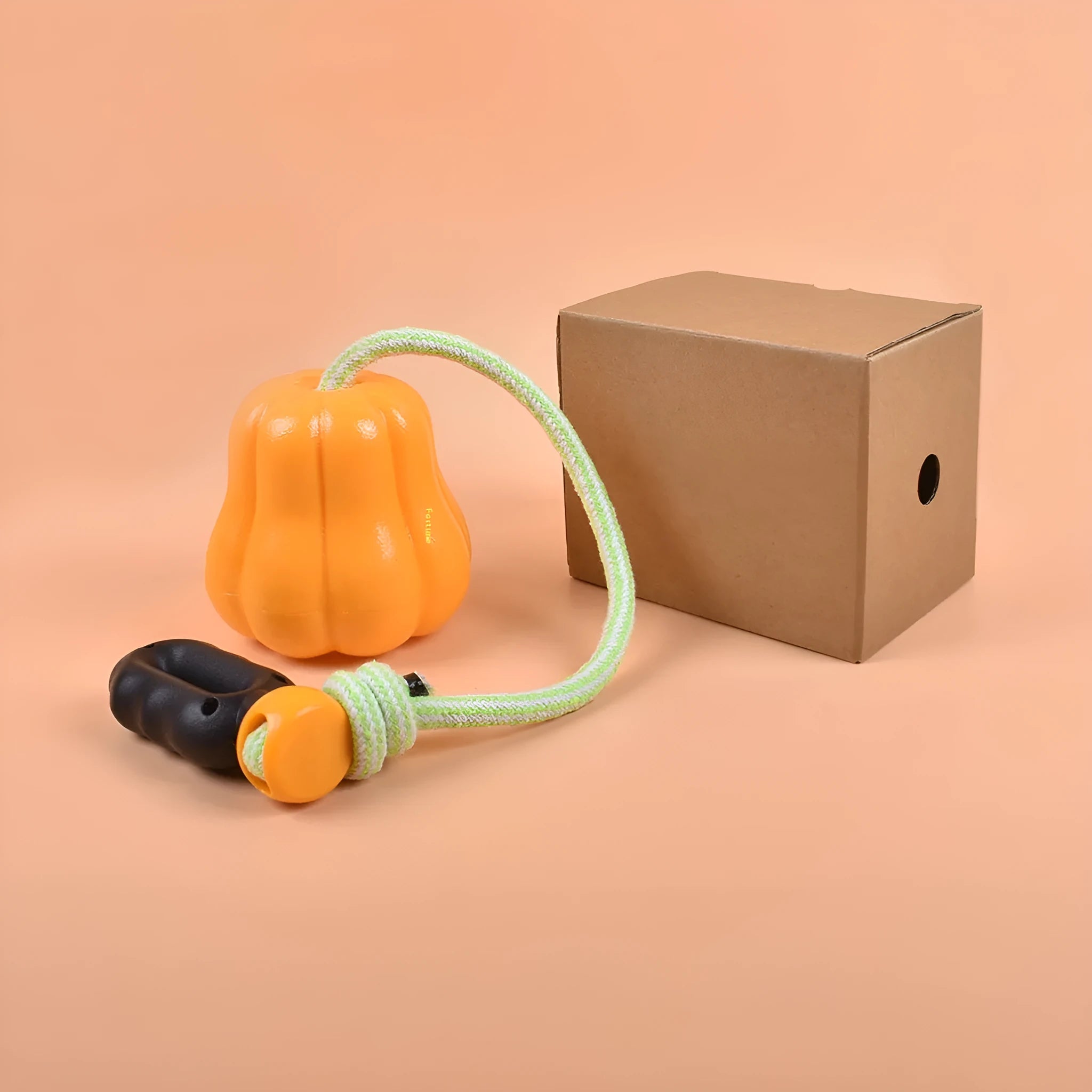Orange plastic dog molar chew toy with a built-in rope for tugging and fetch.