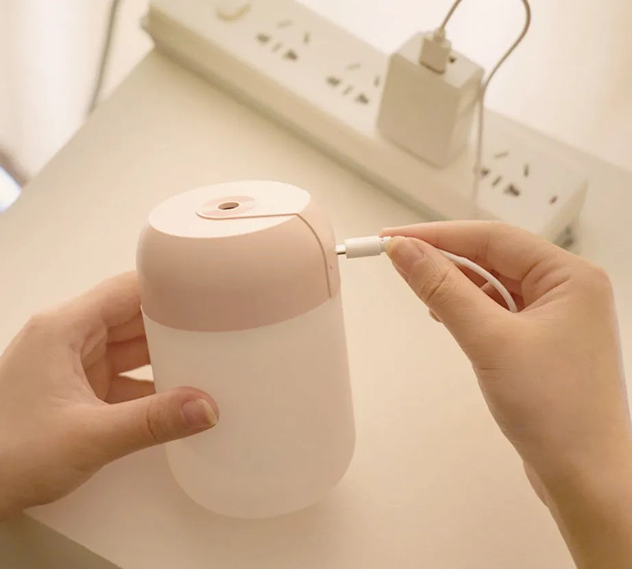Small white cylindrical USB-powered personal humidifier on a desk.