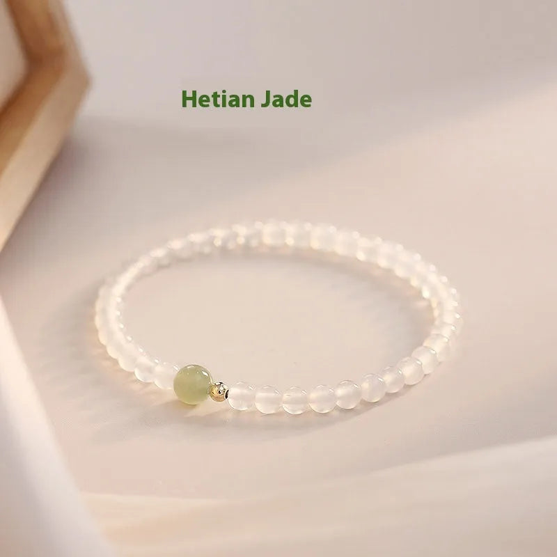 Close-up of a women's bracelet with white agate and Hetian jade beads on a 15 cm strand.