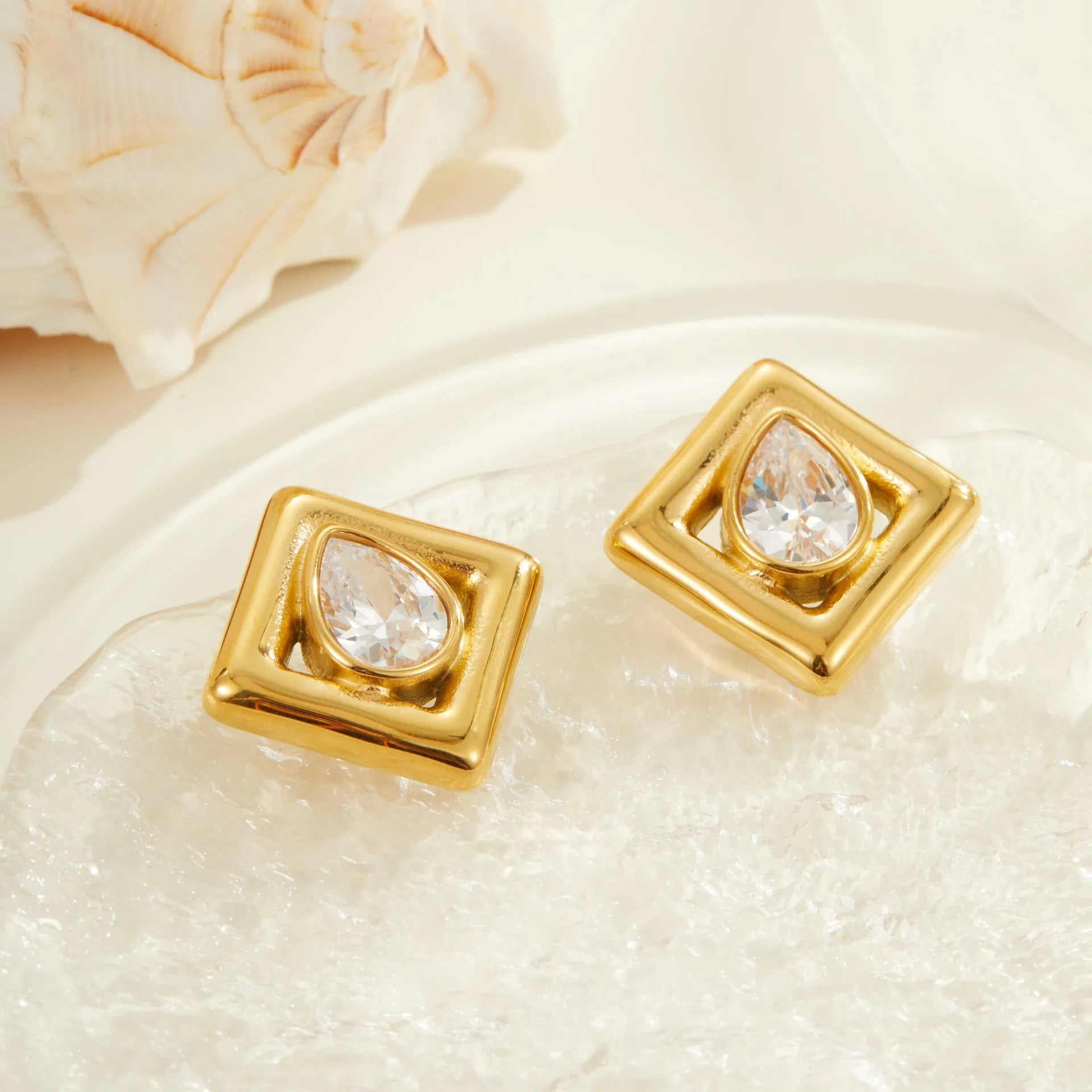 Gold geometric water drop design stud earrings with zircon accents on stainless steel
