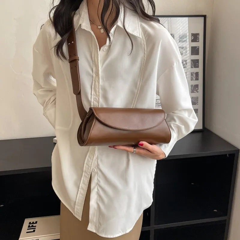 PU leather cylinder crossbody bag in black, horizontal square shape with crossbody strap