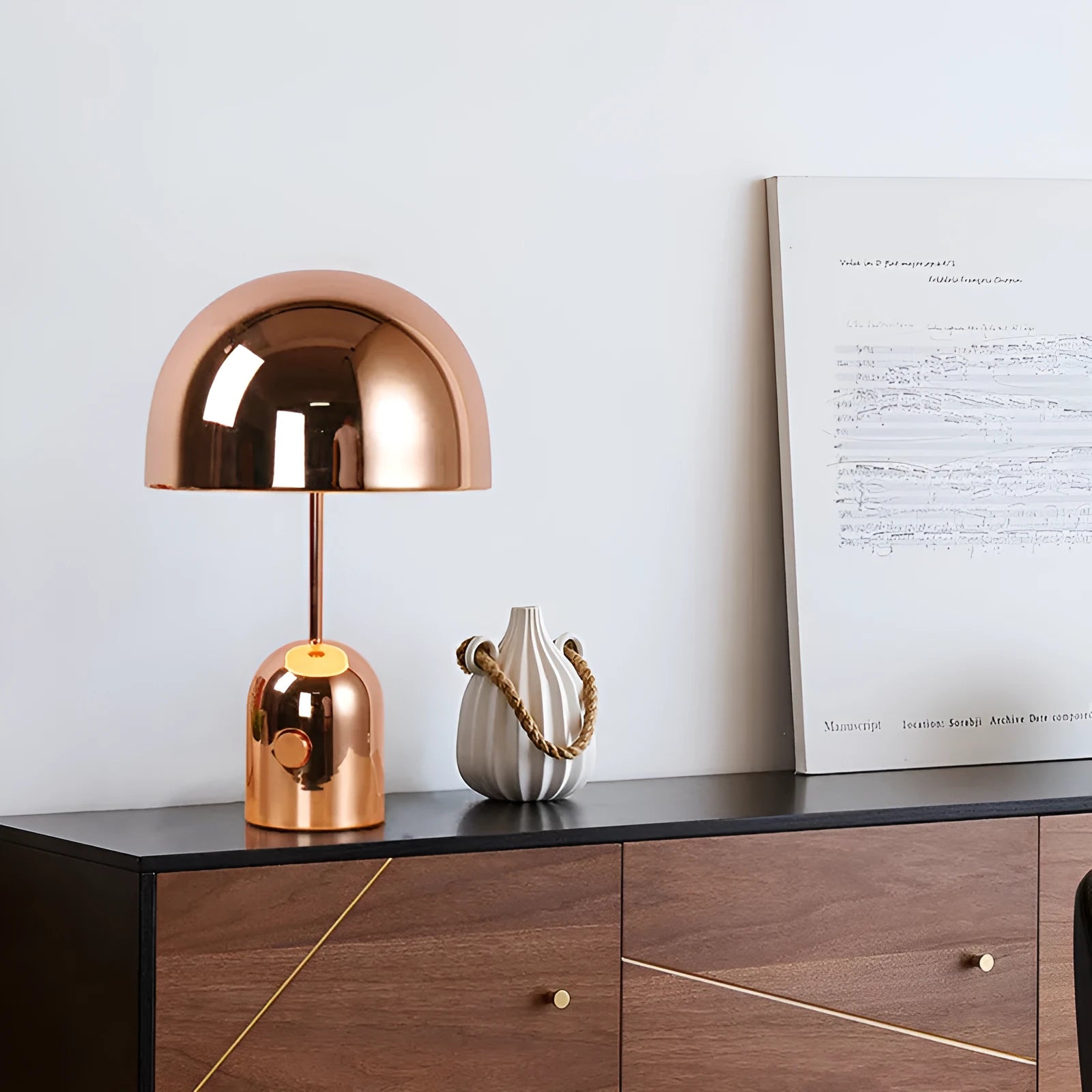 Mushroom-shaped table lamp with metal base in rose gold finish on wooden surface