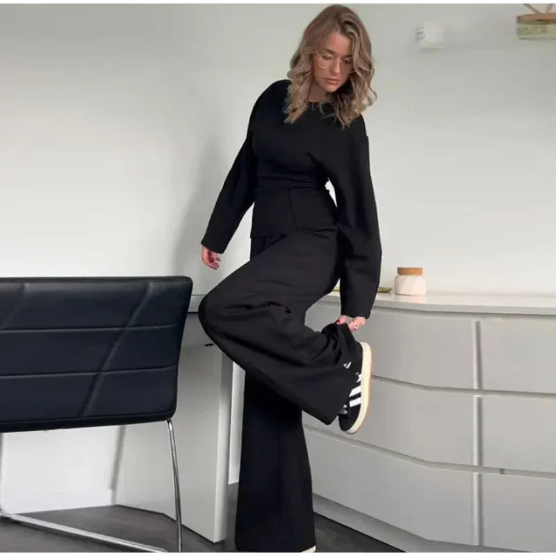 Women's black polyester fleece two-piece suit with long sleeve top and wide-leg trousers on a hanger.