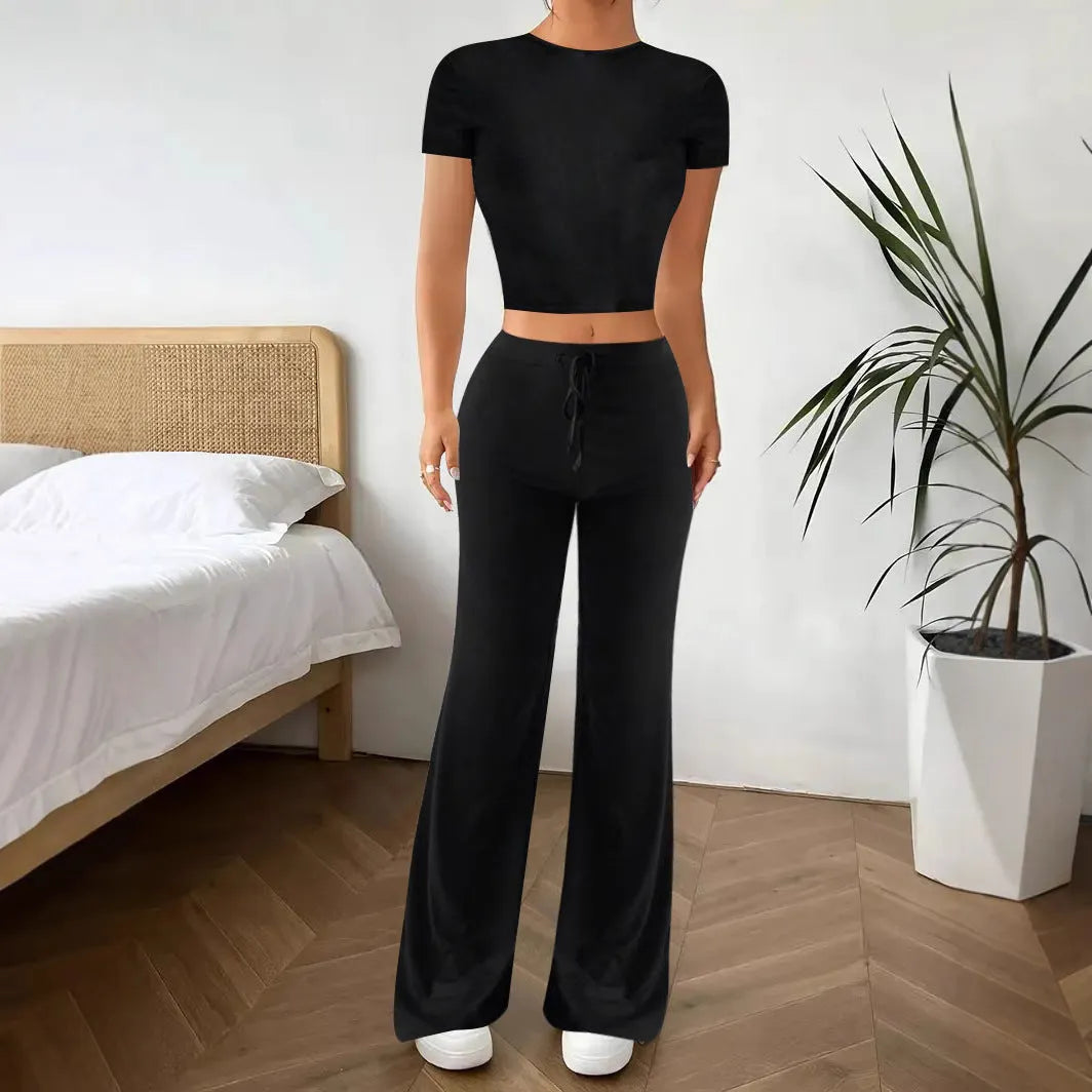 Black women's high waist trousers and short sleeve T-shirt lounge suit set on a plain background.