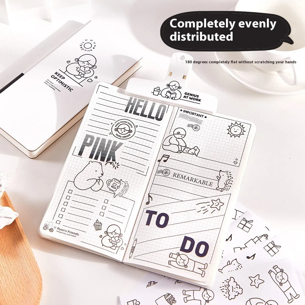 Small white paper notebook with plaid pages, mesh cover, and a pair of decorative stickers.