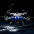 GPS remote control quadrocopter aircraft with dual cameras, spare blades, and handle controller on a table.