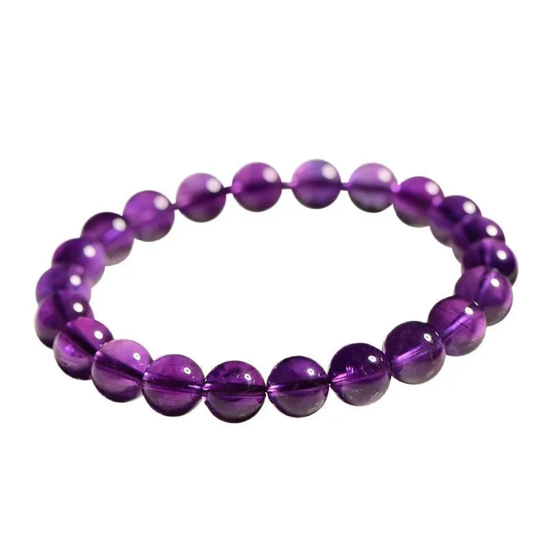 Close-up of a natural purple amethyst bead bracelet with elastic band on a wrist.