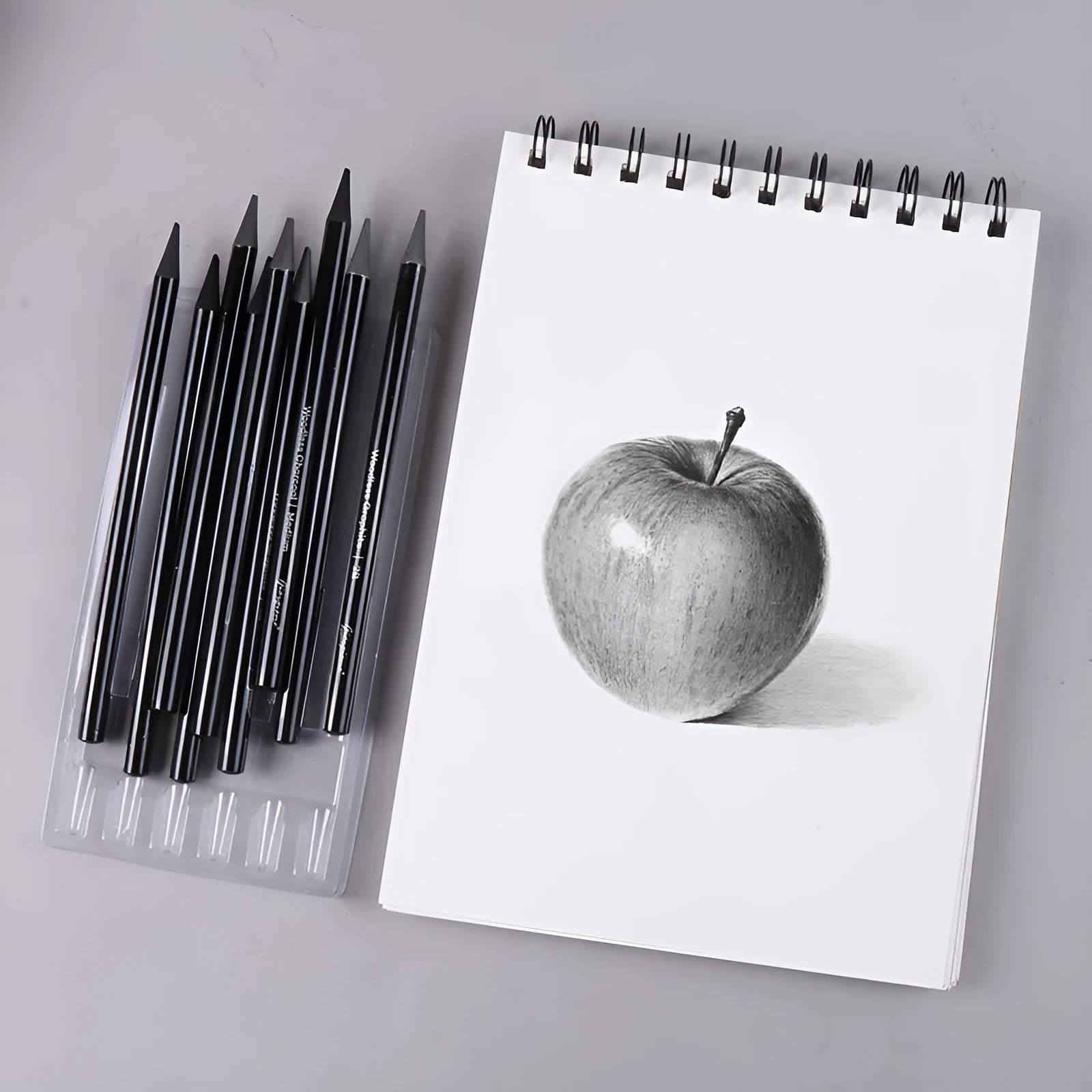 A pack of wooden graphite and carbonised drawing pencils on a suction card.