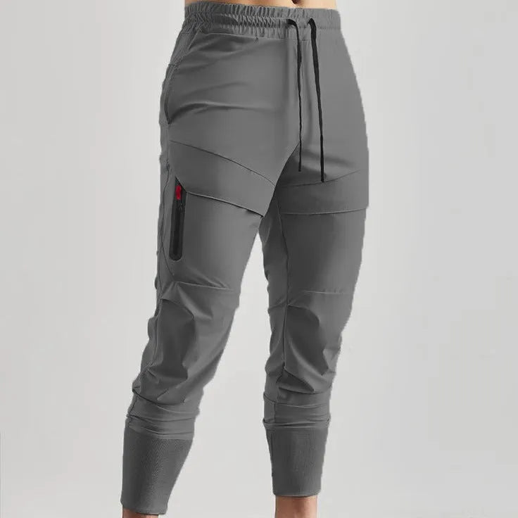 Men's solid colour polyester jogger pants in black, mid-waist micro-elasticity sports trousers for autumn leisure.