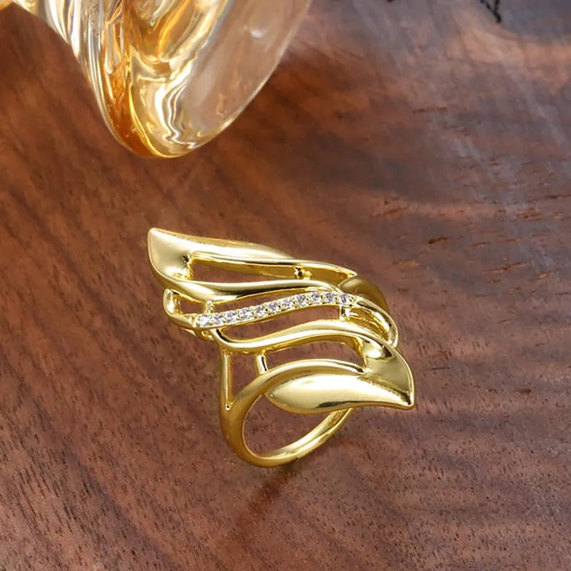 Women's exaggerated curve ring in Q611 gold colour with zircon treatment on copper