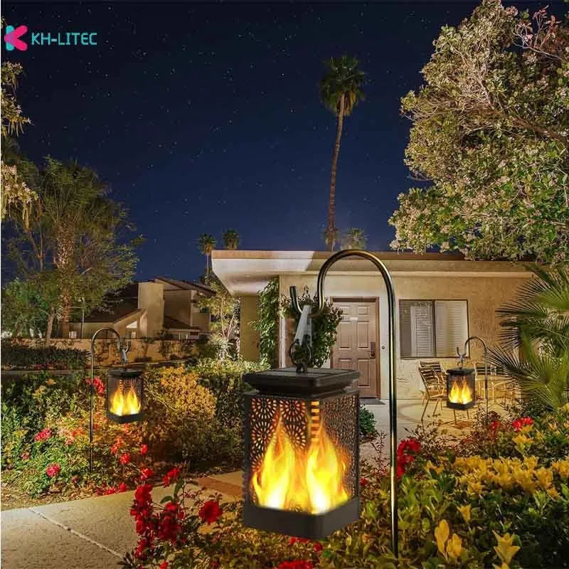 Four black solar-powered outdoor torch lights with flickering LED flame effect, placed on a garden patio.