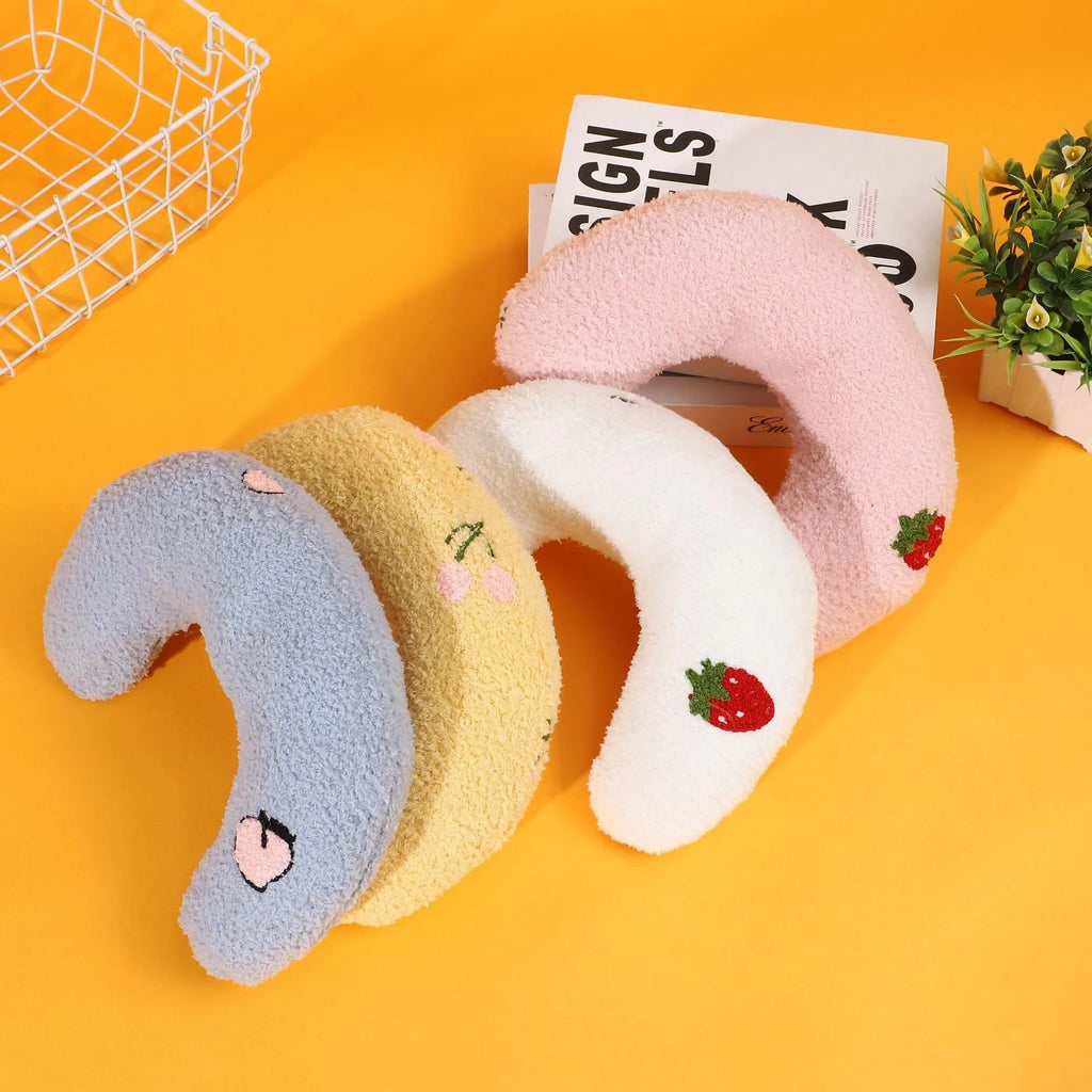 Yellow half-moon shaped cloth pillow with cartoon design for cats and dogs to sleep on.
