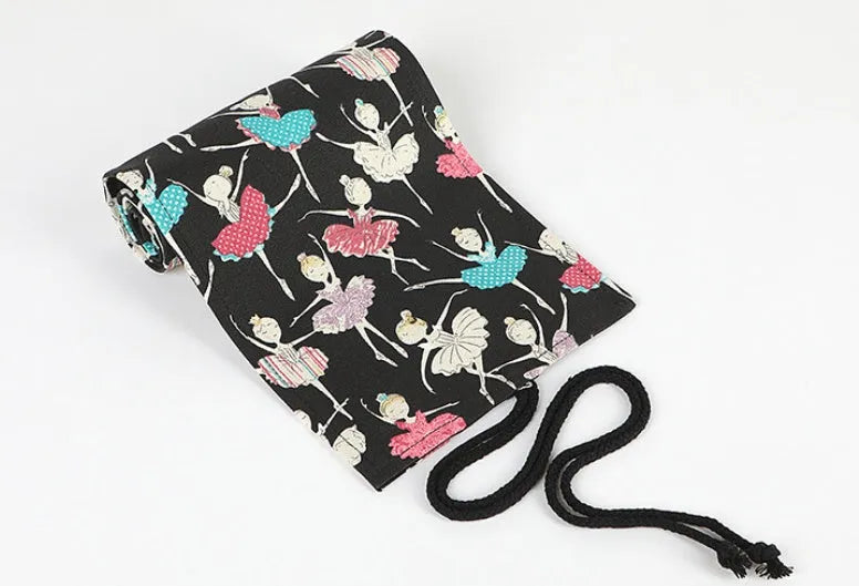 Canvas rolling pencil case with ballet girl print, showing multiple pencils organised in holes.