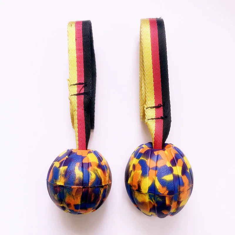 Floating EVA dog training ball with attached string in camouflage and yellow colours, showing three diameter sizes