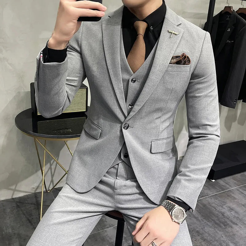Three-piece men's acetate fibre blend business suit set in light gray with jacket, trousers, and vest.