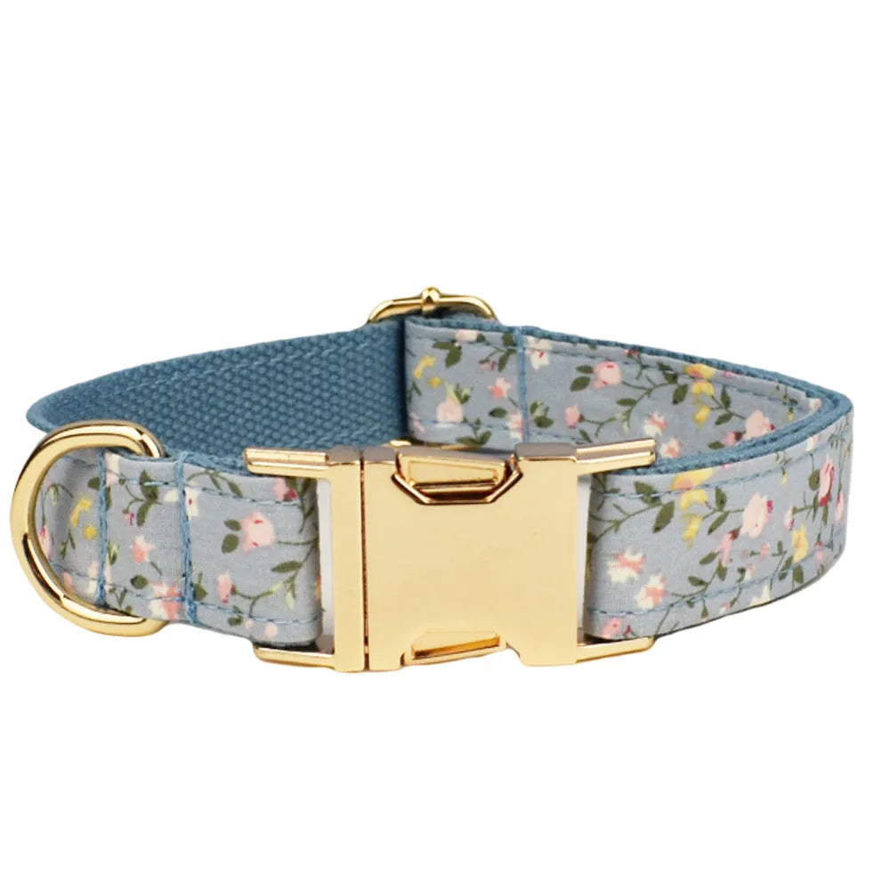 Blue floral patterned dog collar set with leash, bow tie, vest, and poop bag on a white background
