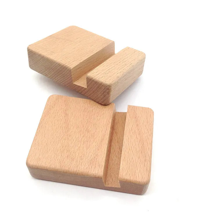 Solid beech wood phone stand with a decorative resin puppy figurine, holding a mobile phone at an angle with a charging cable threaded through the back.