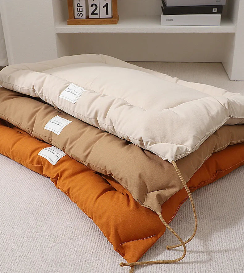 Beige tied cage cushion for small dog in crate showing secure attachment and warm bedding platform.