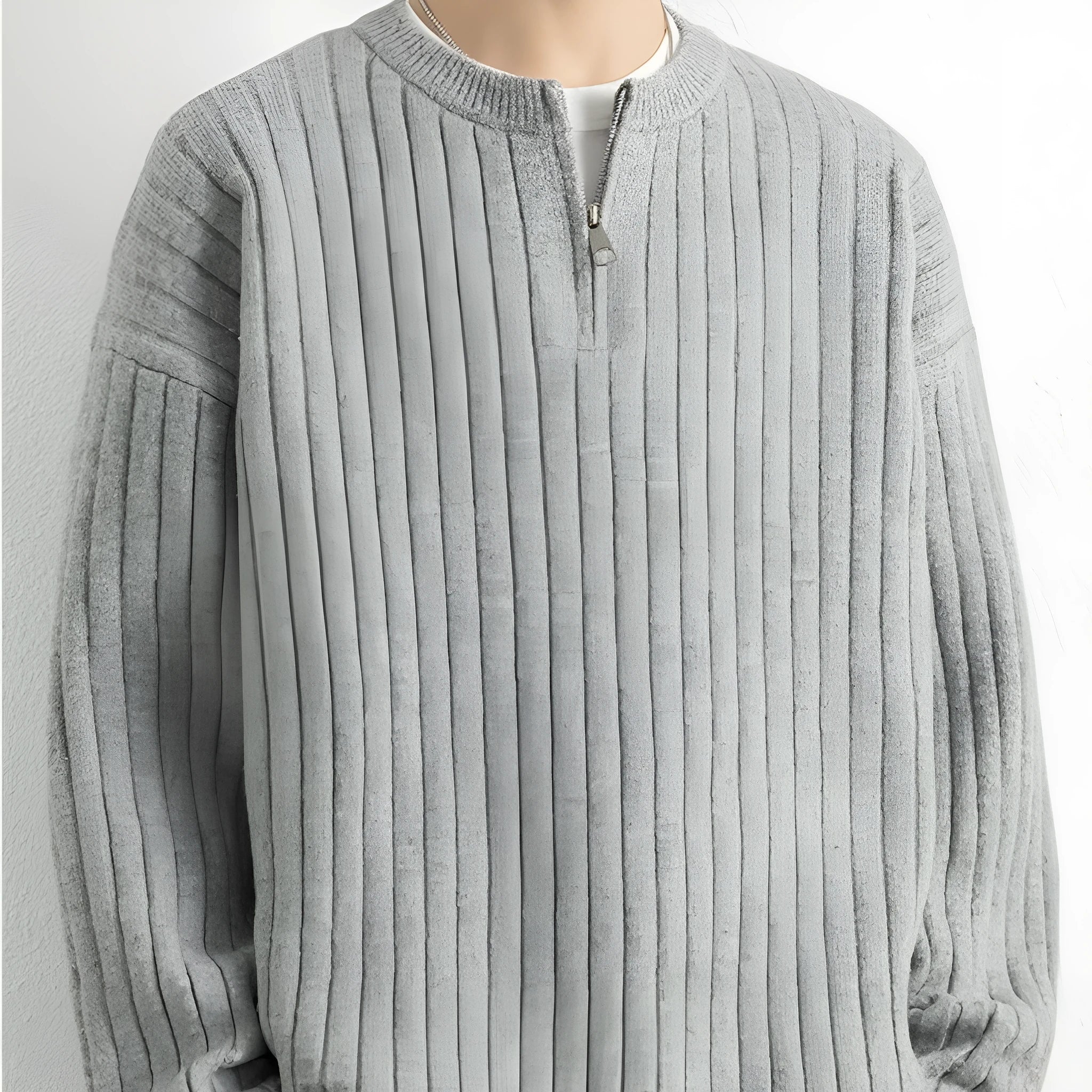 A grey men's textured knit half-zip sweater with a loose fit and long sleeves on a mannequin.