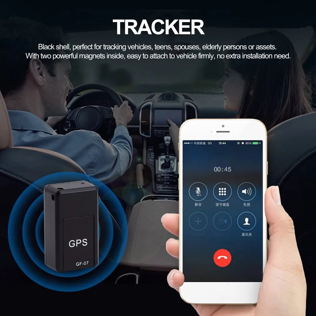 Small black magnetic GPS tracker device next to a micro-USB cable on a table.