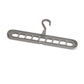 Green nine-hole plastic folding trousers hanger showing garment organisation