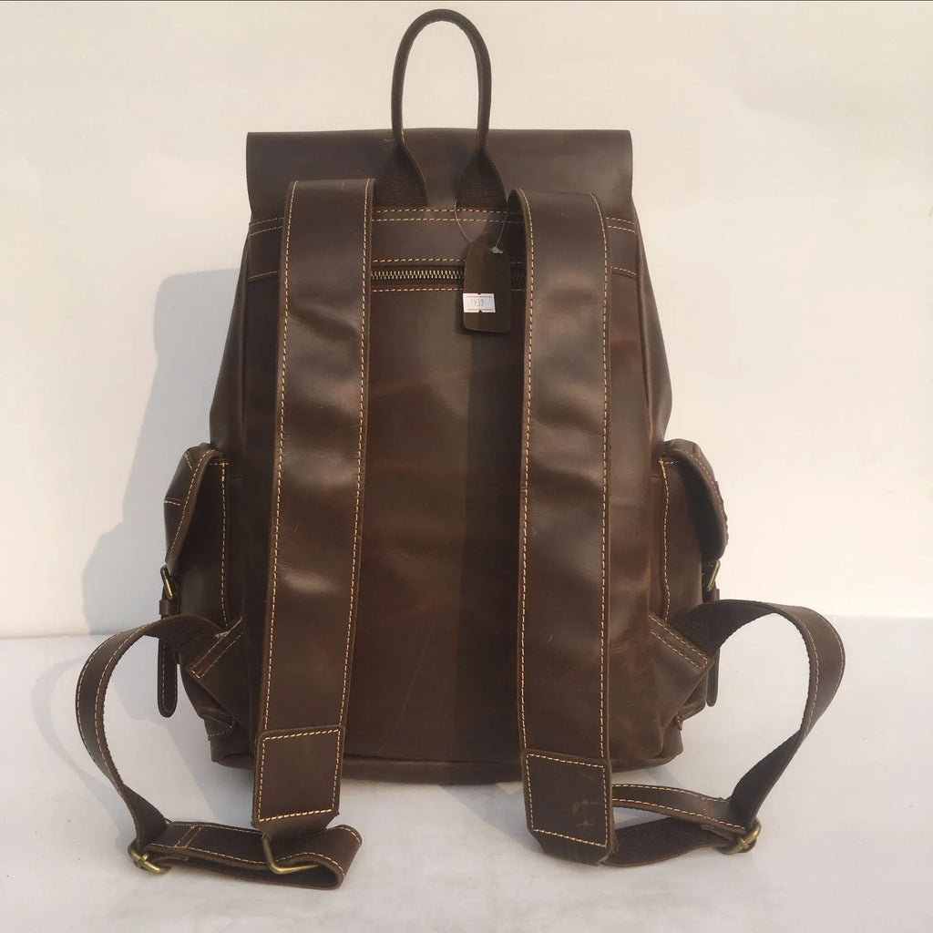 Brown leather men's backpack with shoulder straps showing cowhide leather texture