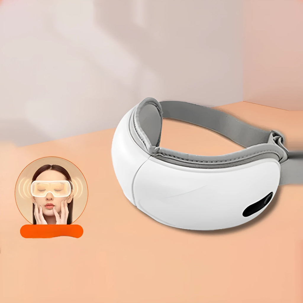 White rechargeable eye massager with hot compress and airbag massage functions on a flat surface
