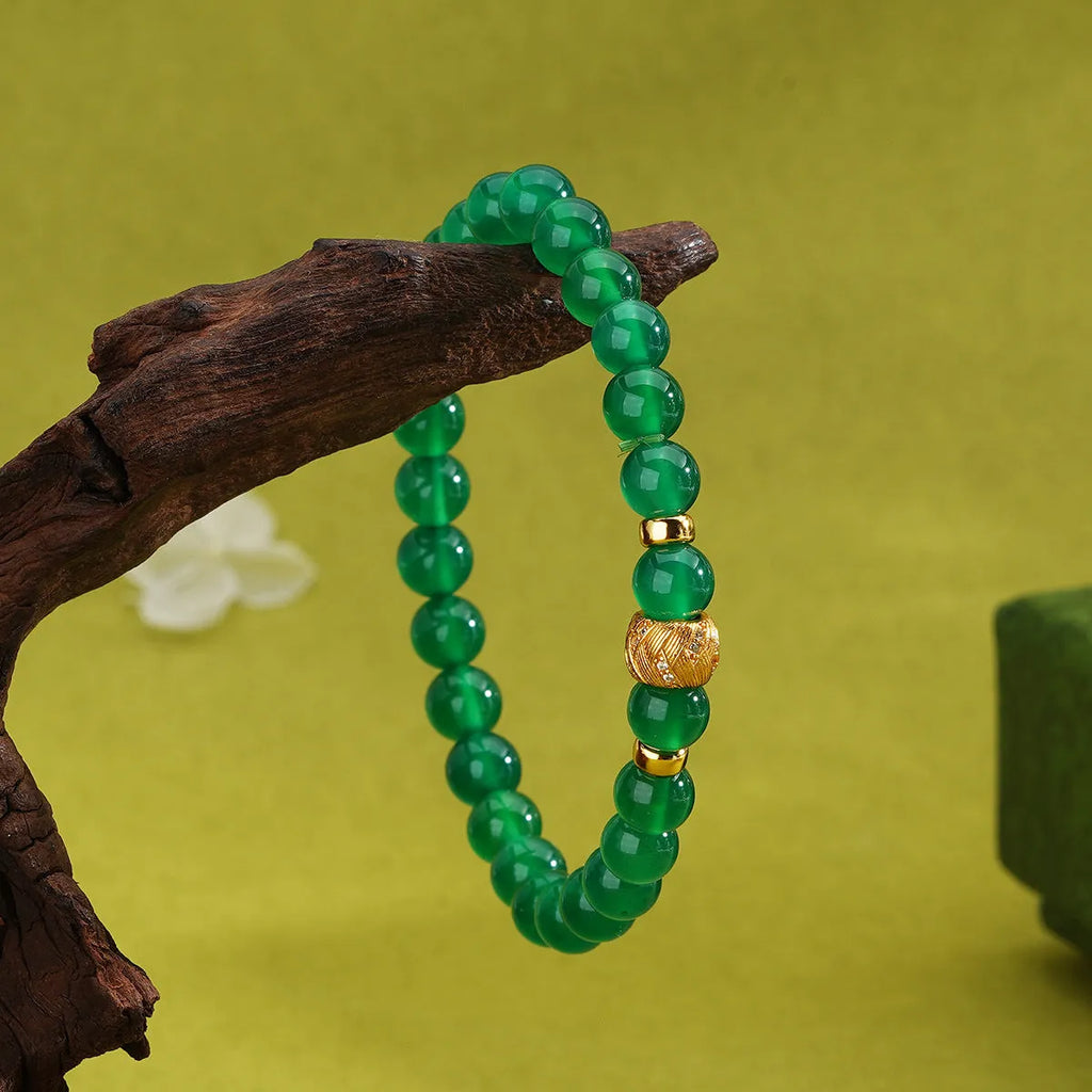 Close-up of a women's bracelet with a green agate stone on a two-tone silver and gold-plated chain.