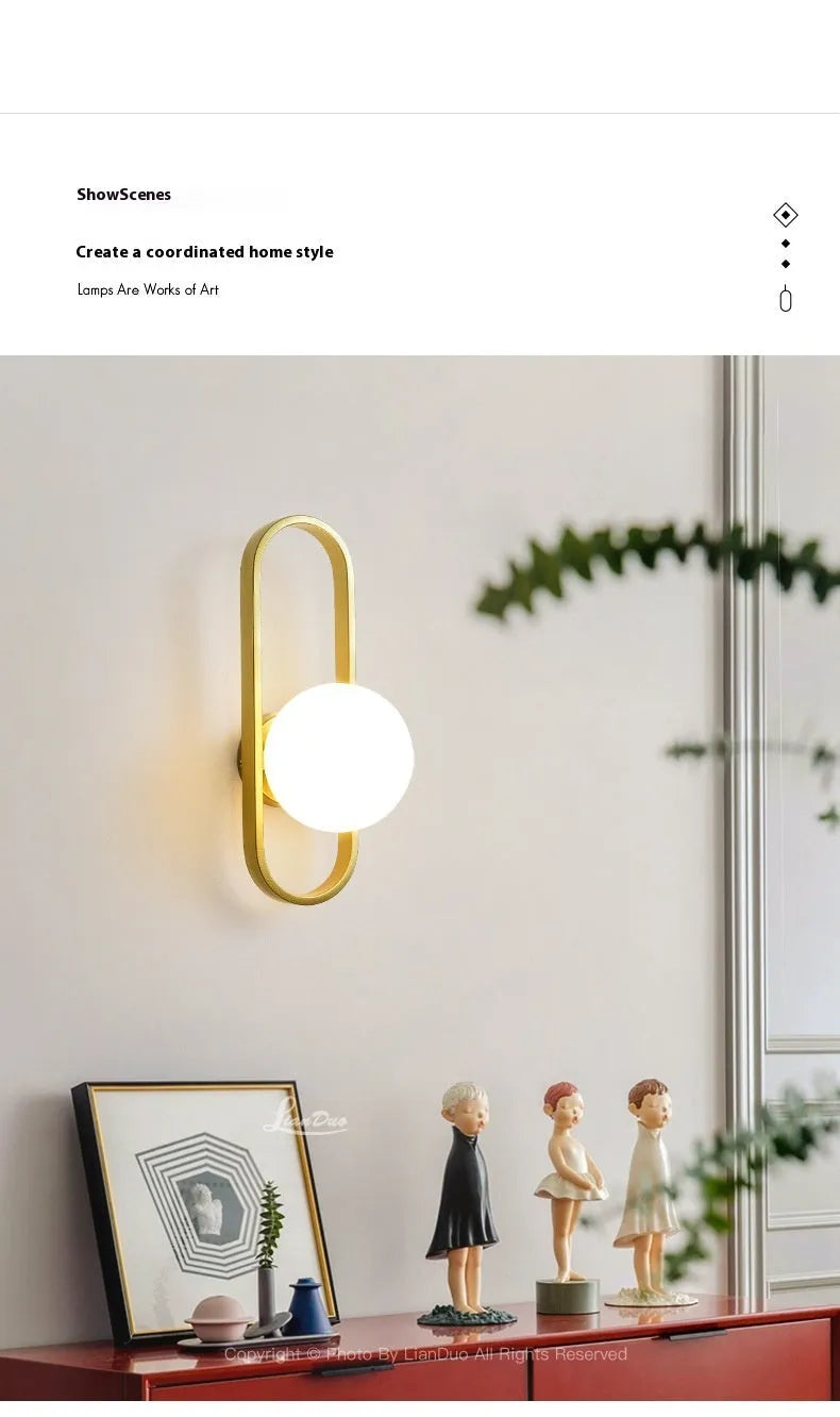 Minimalist wall-mounted lamp with clear glass bulb shade on a black iron sconce arm and backplate.