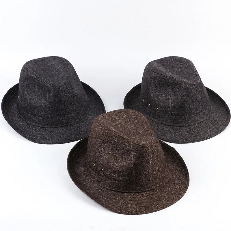 A man's brown fedora hat with a pinched crown and a medium-width brim on a wooden table.